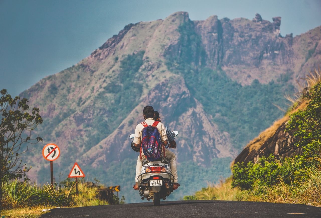 Crafting Captivating Headlines: Your awesome post title goes here Two people on a scooter enjoying a scenic motorcycle ride through a mountain road.