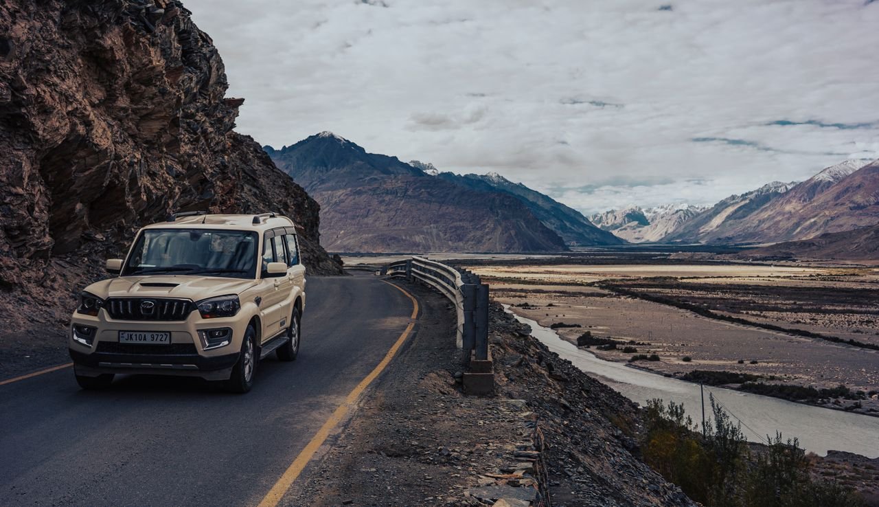 Explore the rugged terrain of Ladakheda, India, with a 4WD adventure vehicle on a mountain road.